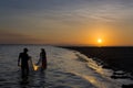 Two fisherman fishing in the shores of the Ometepe Island in Lake Nicaragua, Nicaragua, at sunset