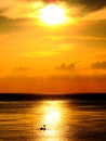 Two fishermen in a boat at sunrise