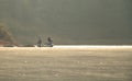 Two fishermen fishing in the misty morning at Mae Ngad Dam and Reservoir. Royalty Free Stock Photo