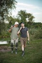 Two fishermen with fishing rods are going fishing near the lake