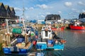 Two fishermen prepare to head out fishing on their boats at Whitstable Harbour in Kent, England.