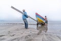 Two fishermen pull the boat