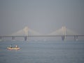 Fishermen sailing on the boat with a bridge on the background Royalty Free Stock Photo