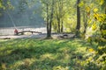 Two fishermen are sitting on the shore near the lake with long rods fishing, talking, enjoying.