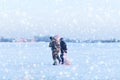 Two fishermen with their catch and fishing gear return from fishing on the ice Royalty Free Stock Photo