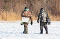Two fishermen walk on the ice while ice fishing Royalty Free Stock Photo