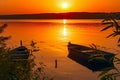 Two fishing boats moored near the shore of a pond against the background of the sunset. Toned. Low key. Royalty Free Stock Photo