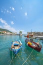 Two fishing boats moored at pier with entrance to fortified medieval harbour behind Royalty Free Stock Photo