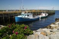 Two fishing boats moored at pier with rocks in foreground. Royalty Free Stock Photo