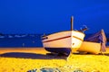Two fishing boats on a sandy beach in the evening against the background of the sea. Royalty Free Stock Photo