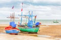 Two fishing boats stand on a shallows, low tide of the ocean with Thai flags Royalty Free Stock Photo