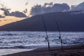 Two fishing rods stuck into a sand on of Kamaole II beach, Kihei, Maui, Hawaii.