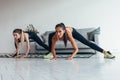 Two fit girls doing home workout performing lateral lunges at home. Royalty Free Stock Photo