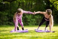 Two fit sporty women giving high five to each other while doing push up on exercise mat in the park Royalty Free Stock Photo