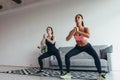 Two fit women exercising together doing squats at home Royalty Free Stock Photo