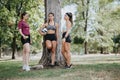 Athletes Discussing and Enjoying a Conversation After Training in a Sunny City Park. They Are Standing Under the Tree. Royalty Free Stock Photo