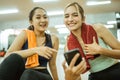 two fit young adult women laughing looking at mobile phone Royalty Free Stock Photo