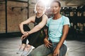 Two fit young friends sitting together after a gym workout Royalty Free Stock Photo