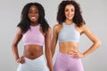 Two fitness women in sportswear isolated over gray background. Sport and fashion concept with copy space. Royalty Free Stock Photo