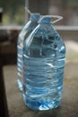 Two five-liter plastic bottles full of water on the table, side Royalty Free Stock Photo