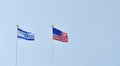 two flags, American and Israeli waving in the blue sky, symbol of cooperation and friendship