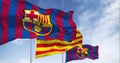 Two flags of FC Barcelona are waving in the wind with the Catalonia flag in the middle