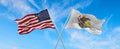 two flags of USA and state of Illinois waving in the wind on flagpoles against sky with clouds on sunny day