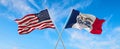 two flags of USA and state of Iowa waving in the wind on flagpoles against sky with clouds on sunny day Royalty Free Stock Photo