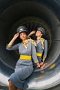 Two flight attendants in pilot caps seated in the aeroengine