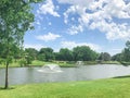 Two floating fountains at residential park with clean pond surrounded by large trees in Coppell, Texas, USA Royalty Free Stock Photo