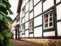 Two-floored building with a white facade and square windows leafs