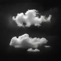 Two fluffy, white clouds float against a dark, monochromatic background, creating a Royalty Free Stock Photo