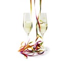 Two flute champagne glasses with colorful paper streamers on white