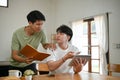 Two focused young Asian male college students do their homework at home together Royalty Free Stock Photo