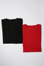 Two folded colorful black and red cotton t shirts isolated on white background. Flat lay tees template Royalty Free Stock Photo