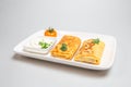 Two folded stuffed savory crepes with sour cream and chives garnish