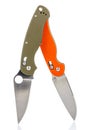 Two folding pocket knifes with open matte blades and textured dark green and orange composite plastic cover plates on steel handle Royalty Free Stock Photo
