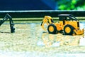 Two folklene toys on a slightly wet cement floor in spring rain are slightly shined in the water.