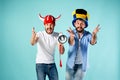 The two football fans with mouthpiece over blue Royalty Free Stock Photo