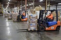 Two forklifts in action, moving boxes in a bustling warehouse setting, Forklifts moving pallets of goods Royalty Free Stock Photo