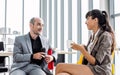 Two formal businesspeople doing workshop, meeting, sitting and discussing together with relaxation in indoor modern office, Royalty Free Stock Photo