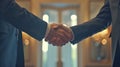 Two Formal Dressed Businessmen Shaking Hands in Elegant Corporate Office Setting with Brass Fixtures and Natural Lighting Royalty Free Stock Photo