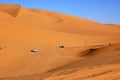 Two four wheel drive vehicles travelling across the Sahara Desert, Libya