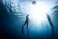 Two free divers ascending from the depth
