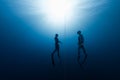 Two free divers ascending from the depth