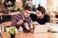 Two freelancer men looking at photos at laptop at desk. Royalty Free Stock Photo