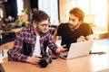 Two freelancer men looking at photos at laptop at desk. Royalty Free Stock Photo