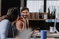 Two freelancers talking while working in shared work area. Concept of coworking, common workspaces for business Royalty Free Stock Photo