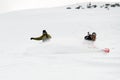 Two freeride snowboarders roundly descends from the mountain in freeride style