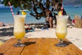 Two fresh alcohol cocktail on the beach. Cold pina colada on seascape background. Pair of cool pineapple cocktails with straw. Royalty Free Stock Photo